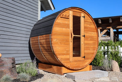 5-ft red cedar barrel outdoor sauna for two people in a landscaped backyard with stone step entry, compact backyard wellness setup