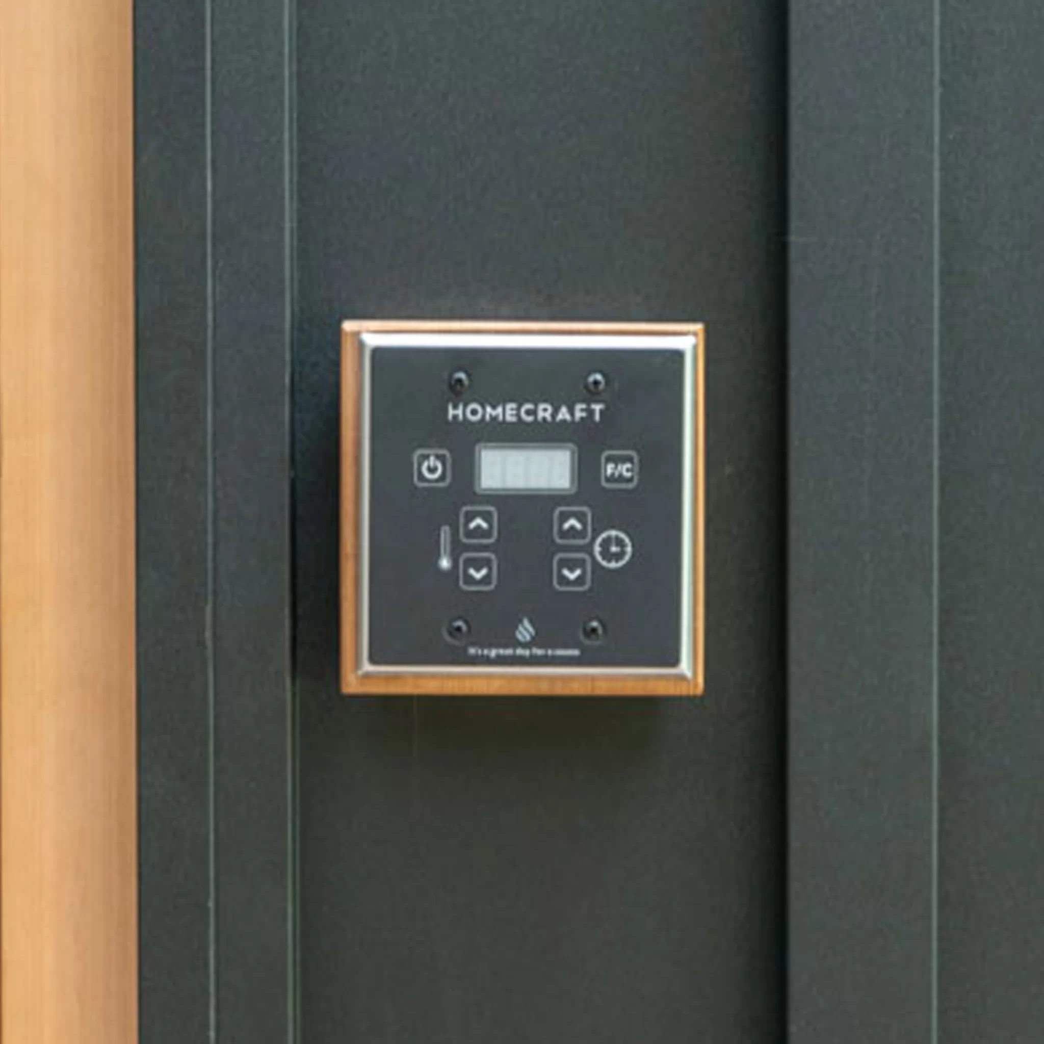 Homecraft sauna heater controller close-up mounted on black sauna wall