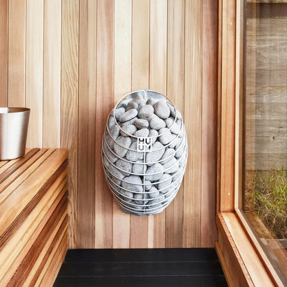 HUUM Drop electric sauna heater wall-mounted in a custom cedar sauna interior, modern sauna heating setup